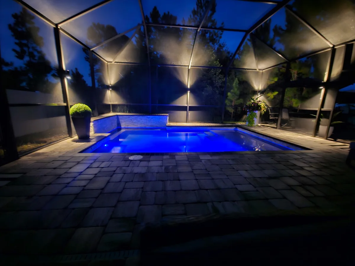 Warm sconces on the enclosure frame, the pool run blue