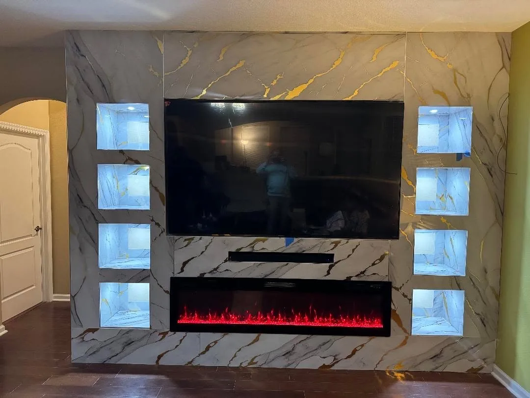 A marble media wall with lit niches and a linear fireplace