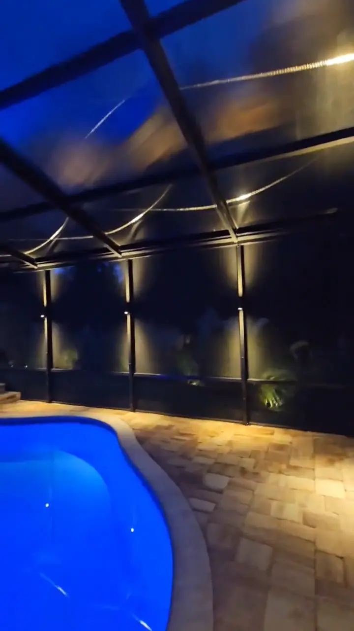 The spa and pool under warm sconces, the water lit blue